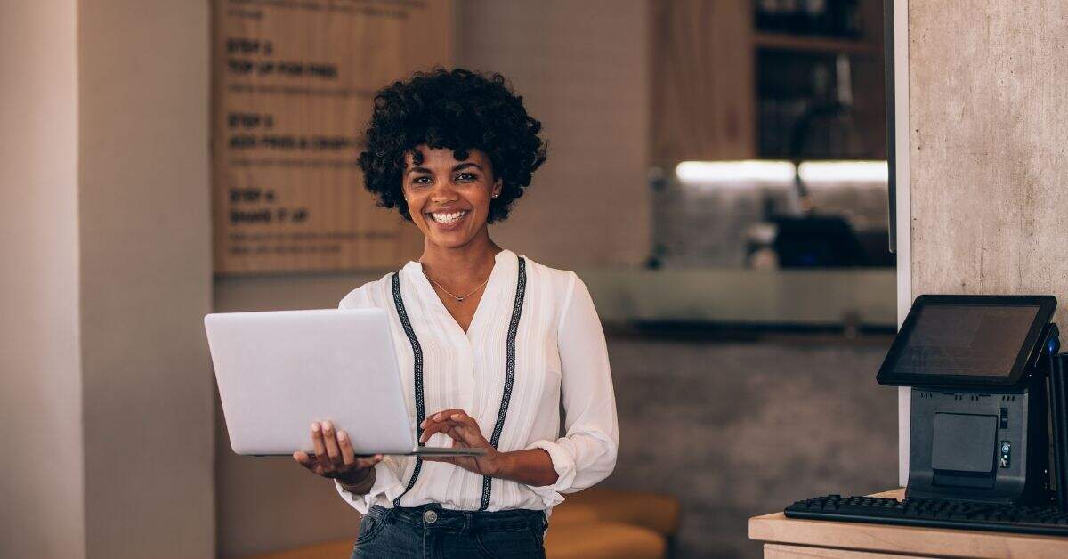 Smiling Botswana business owner using laptop to grow customers online, enjoying the benefits of a website in Botswana