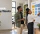 Two business professionals planning project milestones on a wall-mounted project timeline board in a modern office.