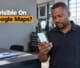 A Botswana business owner looking at a smartphone map application inside a workshop reception office.
