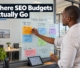 A Botswana business owner organizing marketing expense notes and digital visibility plans on a glass office board.