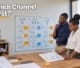 Two business owners evaluating digital marketing pathways on a whiteboard in an office workshop