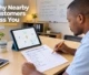 A business owner reviewing a printed checklist and tablet displaying a local map listing on an office desk