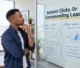 A business owner reviewing organic search growth and paid advertising pathways plotted on a modern glass partition board.